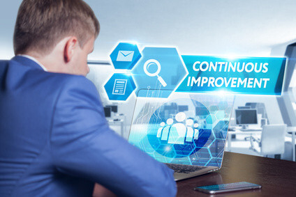 Zoom sur « Business, technology, internet and networking concept. Young businessman working on his laptop in the office, select the icon continuous improvement on the virtual display. » (touche ESC pour fermer)